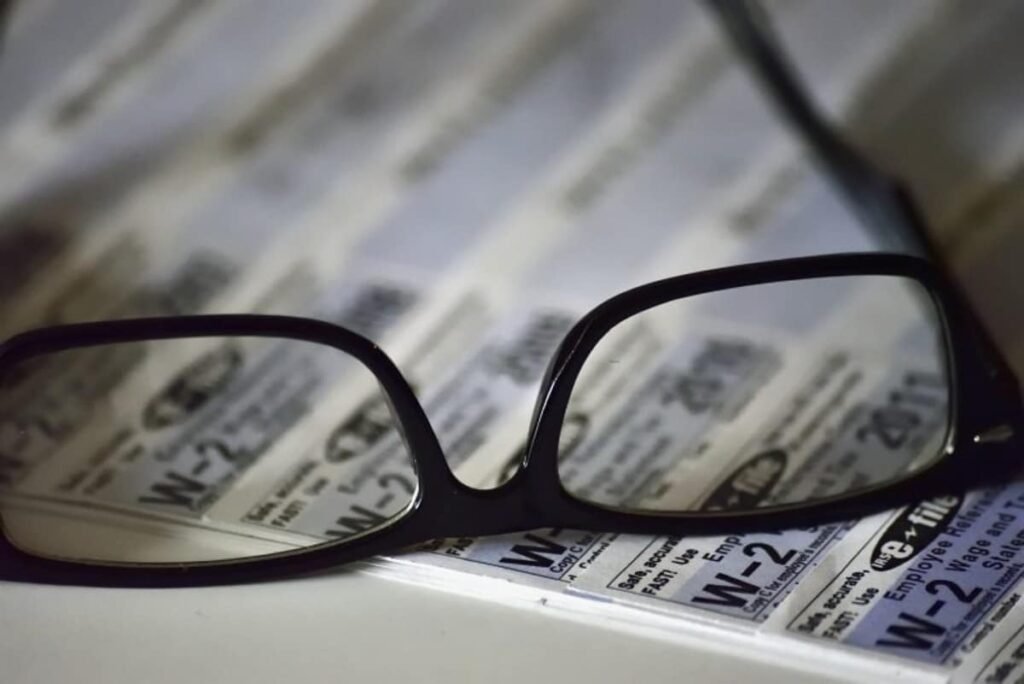 Glasses on a desk, on top of a spreadsheet, representing Common 401k questions