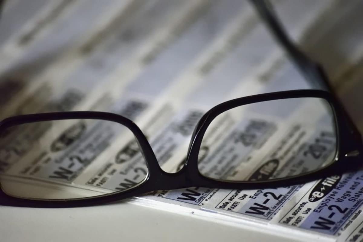 Glasses on a desk, on top of a spreadsheet, representing Common 401k questions